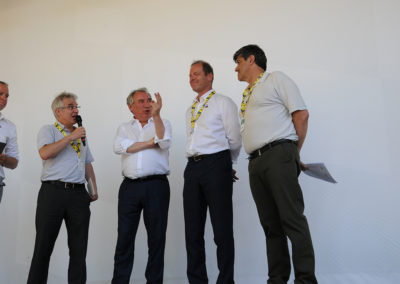 Remise du 15e Prix Jacques-Goddet sur le podium du Village du Tour, à Pau, le 19 juillet 2019, cent ans jour pour jour après la création du maillot jaune. Au nom d’Edeis l’Allié des territoire, partenaire du Prix, Christophe Penot ouvre la cérémonie, tandis que François Bayrou, maire de la ville, salue déjà Jean-Luc Gatellier, premier journaliste à inscrire deux fois son nom au palmarès.